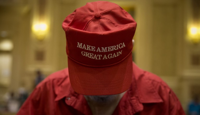 An attendee wears a "Make America Great Again" hat .