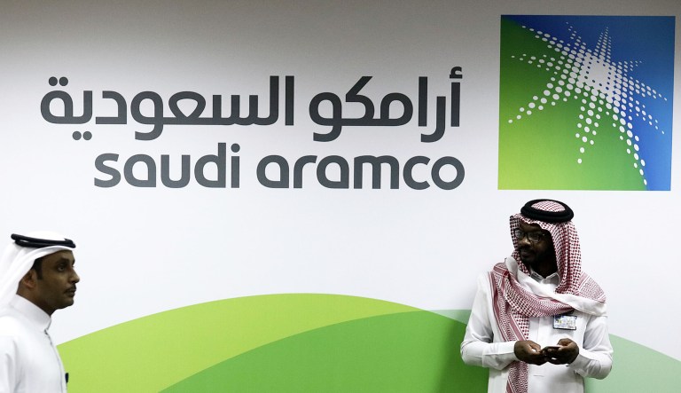 Attendees walk by a sign for the Saudi Arabian Oil Co. (Aramco) on display inside the King Abdulaziz Center for World Culture during a tour of the project in Dhahran, Saudi Arabia.