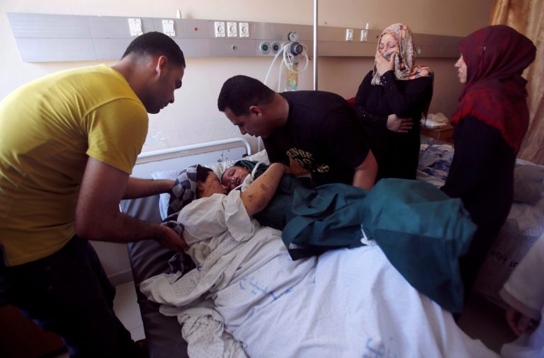 Mohammed al-Bakri brings the body of his three-year-old son Kamal to the boy's wounded mother, Dua, at the Shifa hospital in Gaza City, Tuesday, Aug. 5, 2014. The boy was killed Monday along with two other family members in an Israeli missile strike on their home in Shati refugee camp, Gaza City. (AP Photo/Hatem Moussa)