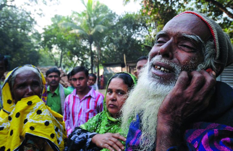 A Bangladeshi man, right, reacts as he looks for his son's body outside a garment factory where a fire killed more than 110 people Saturday on the outskirts of Dhaka, Bangladesh, Monday, Nov. 26, 2012. Bangladeshis Monday blocked the streets near Dhaka, throwing stones at factories and smashing vehicles, as they demanded justice for those killed in the fire. Saturday's blaze highlighted unsafe conditions in an industry producing for retailers around the world. (AP Photo)