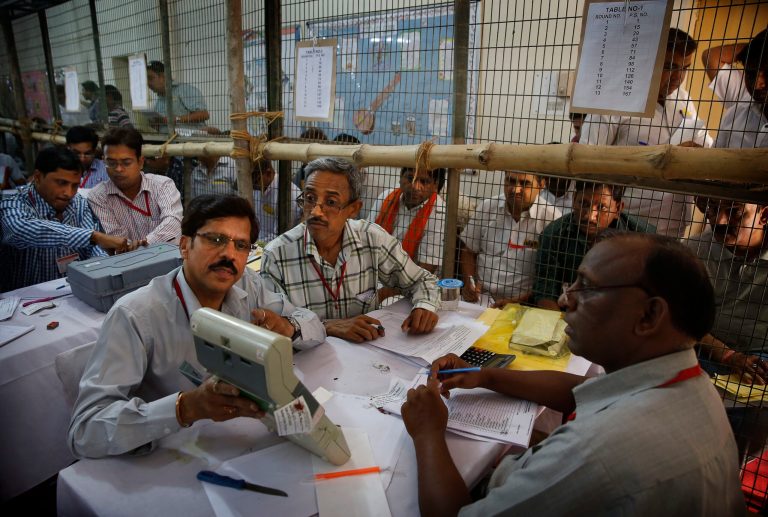 An election official shows an electronic voting machine to a polling agent during counting of votes in New Delhi, India, Friday, May 16, 2014. India's main Hindu nationalist party was making early gains Friday as officials began counting votes following the country's massive national election, with the opposition looking to end the ruling Congress party's decade-long reign. The Election Commission was expected to announce the results later in the day. (AP Photo/Manish Swarup)