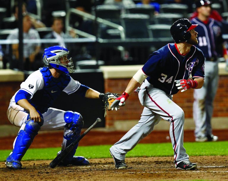 NEW YORK - SEPTEMBER 11:  Bryce Harper #34 of the Washington Nationals hits an RBI single in front of Josh Thole #30 of the New York Mets during a game at Citi Field on September 11, 2012 in the Flushing neighborhood of the Queens borough of New York City.  (Photo by Jeff Zelevansky/Getty Images)