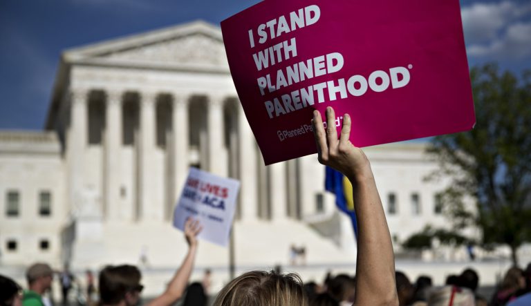 A demonstrator holds a sign that reads "I Stand With Planned Parenthood" while marching near the Supreme Court in Washington, D.C., on Wednesday, June 28, 2017. 