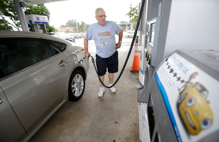 In this Wednesday, June 4, 2014 photo, Marty Mascio, of Pembroke Pines, Fla., pumps gasoline into his car at a Chevron gasoline station in Pembroke Pines, Fla. The Labor Department reports on U.S. consumer prices in May on Tuesday, June 17, 2014. (AP Photo/Wilfredo Lee)