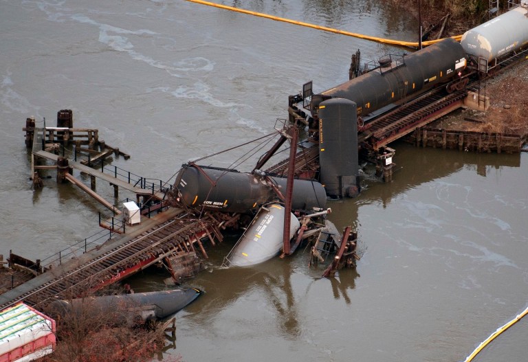   Derailed freight train cars lay in water in Paulsboro, N.J., Friday, Nov. 30, 2012. People in three southern New Jersey towns were told Friday to stay inside after the freight train derailed and several tanker cars carrying hazardous materials toppled from a bridge and into a creek. (AP Photo/Cliff Owen)  