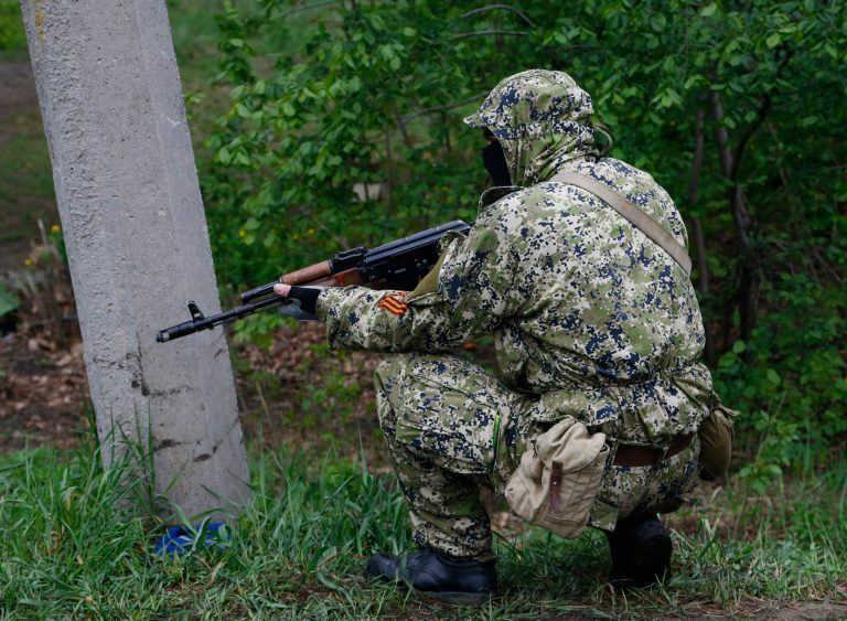 A pro Russian masked armed militant guards barricades near Slovyansk, eastern Ukraine, Wednesday, April 30, 2014. (AP Photo/Sergei Grits)