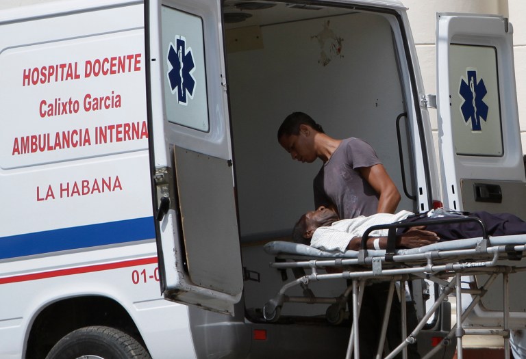 FILE - In this Aug 13, 2012 file photo, a sick man is taken by ambulance to the public hospital Calixto Garcia in Havana, Cuba. Cuban authorities say they have eliminated more than 100,000 jobs in health care, considered one of the 