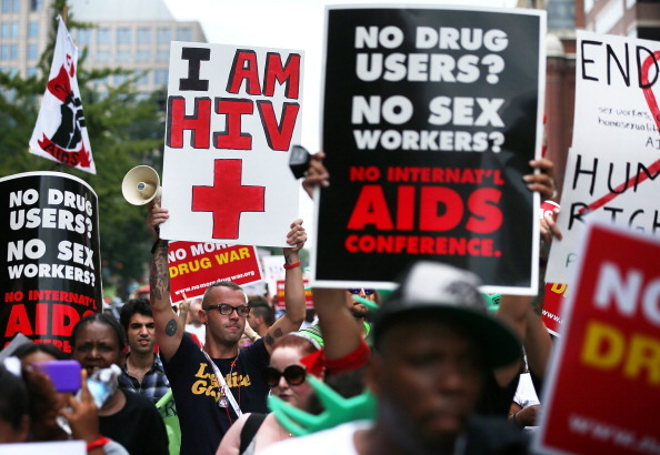 WASHINGTON, DC - JULY 24:  HIV+ patient Aaron Laxton (Center R) of St. Louis, Missouri, and other activists participate in a march from the Washington Convention Center to the White House July 24, 2012 in Washington, DC. AIDS activists from organizations all around the world participated in the march to 