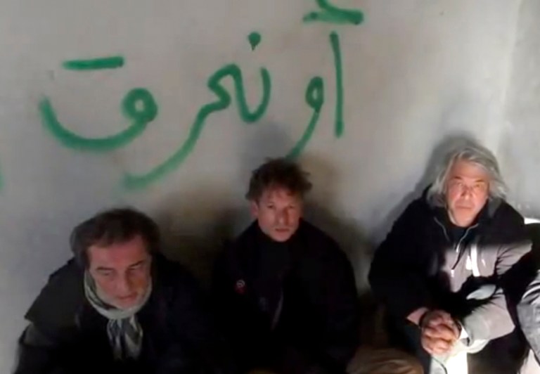 In this file image taken from undated amateur video posted on the Internet, NBC chief foreign correspondent Richard Engel, center, with NBC Turkey reporter Aziz Akyavas, left, and NBC photographer John Kooistra are seen after they were taken hostage in Syria. (AP Photo/Amateur Video, File)