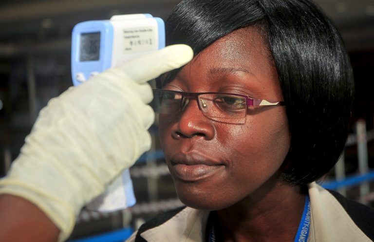 A passenger arriving at the airport has her temperature checked to screen for fevers that could indicate symptoms of Ebola, amongst other illnesses, in Entebbe, Uganda, Thursday, Nov. 13, 2014. (AP Photo/Stephen Wandera)