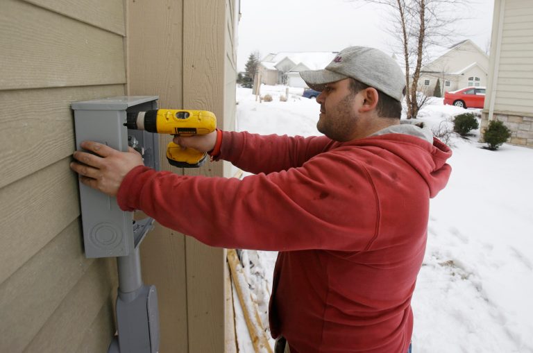 In this Friday, Jan. 10, 2014, photo, Paquale Cocca installs a new electrical box on a new home, in Pepper Pike, Ohio. The Commerce Department releases housing starts for January on Wednesday, Feb. 19, 2014. (AP Photo/Tony Dejak)