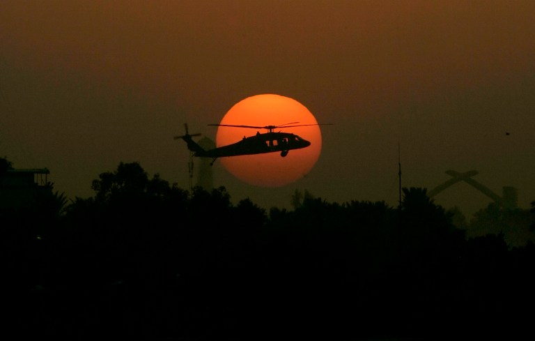A U.S. Army Black Hawk helicopter flies as the sun sets over Baghdad, Iraq, in this Oct. 30, 2007, file photo. (AP Photo/Marko Drobnjakovic, File)
