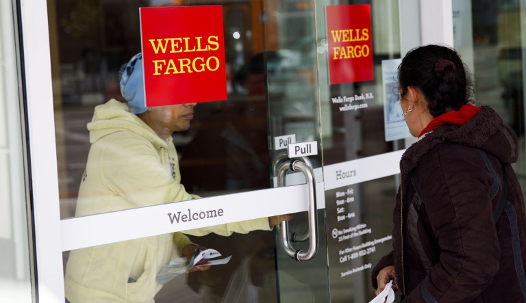 A customer exits a Wells Fargo & Co. bank branch in Los Angeles, California, U.S., on Thursday, April 19, 2018. Wells Fargo & Co.'s financial ties to gunmakers and the National Rifle Association have prompted the American Federation of Teachers to remove the bank from its list of recommended mortgage lenders.