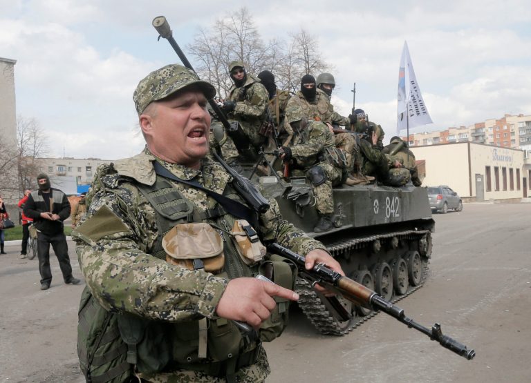A pro-Russian gunman clears the way for a combat vehicle with gunmen on top in Slovyansk, Ukraine, on Wednesday. (AP/Efrem Lukatsky)