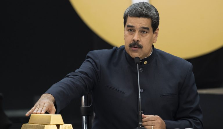 Nicolas Maduro, Venezuela's president, speaks as he touches a stack of 12 Kilogram gold ingots during a news conference on the country's cryptocurrency, known as theÂ Petro, in Caracas, Venezuela, on Thursday, March 22, 2018.
