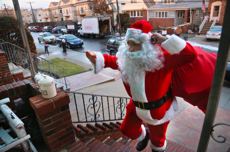   In this Tuesday, Dec. 18, 2012 photo, Michael Sciaraffo, as Santa Claus, arrives at the home of the Creamer family to deliver toys in the Belle Harbor neighborhood of the Queens borough of New York. Using Facebook, Sciaraffo started a charitable enterprise to collect and personally deliver toys to children affected by superstorm Sandy, dressed as Santa Claus. (AP Photo/Bebeto Matthews)  