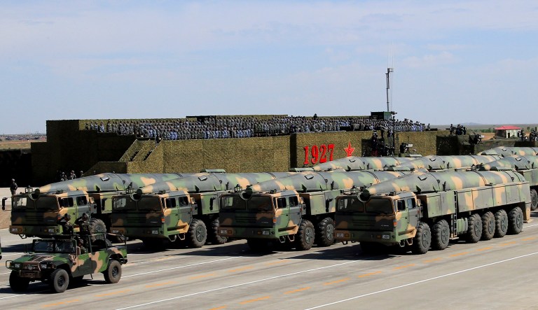 Military vehicles carrying missiles for both nuclear and conventional strikes are driven past the VIP stage during a military parade in China. U.S. officials said China conducted a series of missile tests that were designed to coincide with celebrations for China's Army Day on Aug. 1. (Zha Chunming/Xinhua via AP)