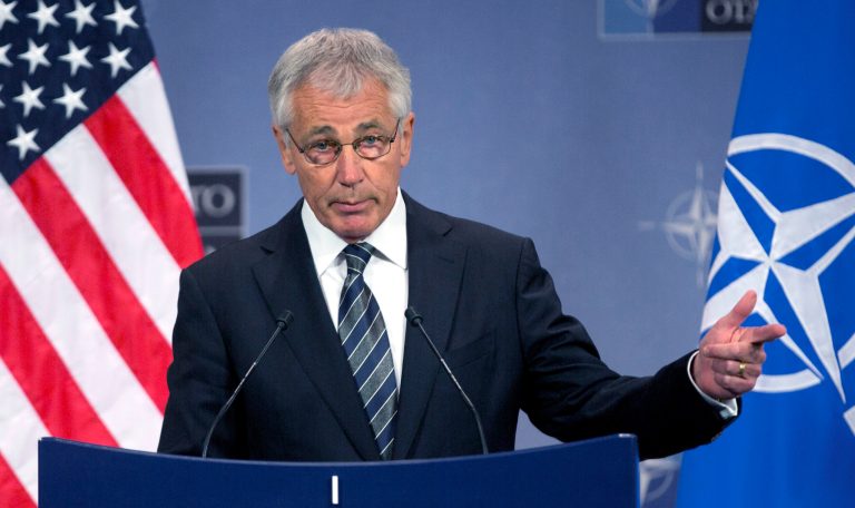 FILE - In this Oct. 23, 2013 file photo, Secretary of Defense Chuck Hagel speaks during a media conference after a meeting of NATO defense ministers at NATO headquarters in Brussels. Defense Secretary Chuck Hagel on Thursday, Oct. 31, 2013 sharply criticized U.S. states that are defying the Pentagon by refusing to allow National Guard facilities to issue ID cards that enable same-sex spouses of military members to claim benefits. (AP Photo/Virginia Mayo, File)
