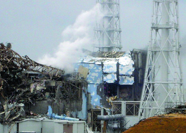 FILE - In this March 15, 2011 file photo released by Tokyo Electric Power Co., smoke rises from the badly damaged Unit 3 reactor, left, next to the Unit 4 reactor covered by an outer wall at the Fukushima Dai-ichi nuclear complex in Okuma, northeastern Japan. The emergency command center at Japan's stricken nuclear plant shook violently when hydrogen exploded at Unit 3 and the plant chief reacted by shouting, 