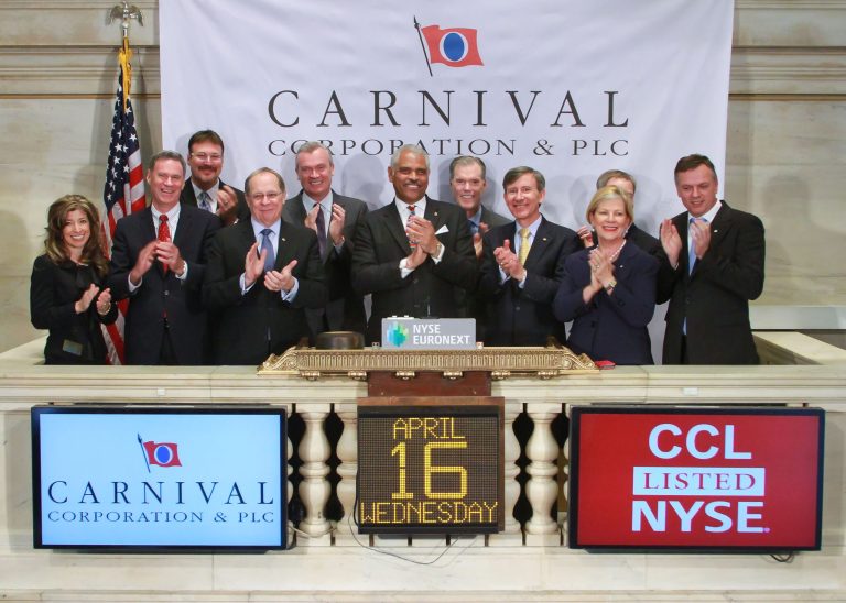In this photo provided by the New York Stock Exchange Euronext, Carnival Corporation President and Chief Executive Officer, Arnold W. Donald, center, and guests, gather on the podium for the closing bell at the Exchange on Wednesday, April 16, 2014, in New York. Carnival Corporation is headquartered in Doral, Fla; a suburb of Miami. (AP Photo/New York Stock Exchange Euronext, Dario Cantatore)