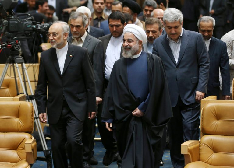 Iranian President Hassan Rouhani, center, arrives to attend a ceremony marking National Nuclear Technology Day, as he is accompanied by head of Iran's Atomic Energy Organization Ali Akbar Salehi, left, and Vice President for science and technology affairs Sorena Sattari, right, in Tehran, Iran. (AP Photo/Vahid Salemi)