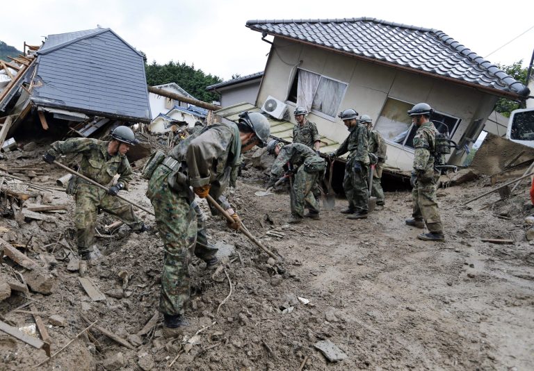 Japan Ground Self Defense Force personnel search for missing residents in a mud-ridden residential area following a massive landslide in Hiroshima, western Japan, Thursday, Aug. 21, 2014. Rain-sodden slopes collapsed in torrents of mud, rock and debris Wednesday on the outskirts of Hiroshima city, killing more than 30 people and leaving a several missing, Japanese police said. (AP Photo/Kyodo News) JAPAN OUT