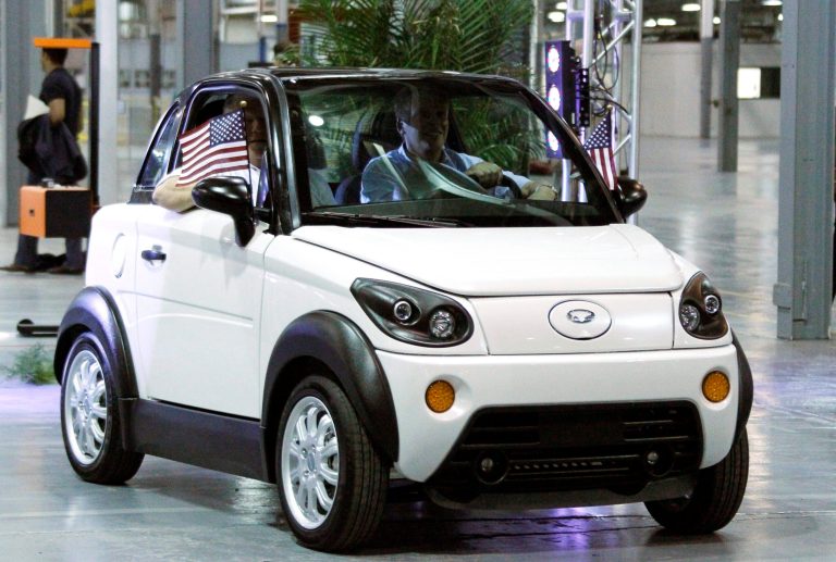 Former Mississippi Gov. Haley Barbour, left, and GreenTech Automotive chairman Terry McAuliffe drive one of the first MyCars during their unveiling at their manufacturing facility in Horn Lake, Miss., in 2012. (AP/Rogelio V. Solis)