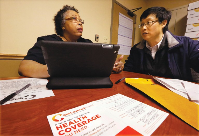 A navigator helps Min Lians, who is seeking help buying health insurance under the Affordable Care Act, at the Family Guidance Center in Springfield, Ill. (AP/Seth Perlman)