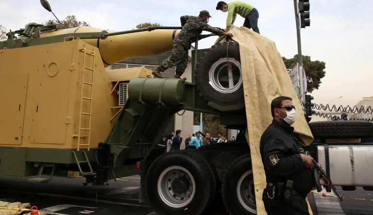 Islamic Revolutionary Guard Corps members cover a surface-to-surface missile after it was displayed in an annual gathering in front of the former U.S. Embassy marking the anniversary of its 1979 takeover, in Tehran, Iran, Saturday, Nov. 4, 2017. (AP Photo/Vahid Salemi)