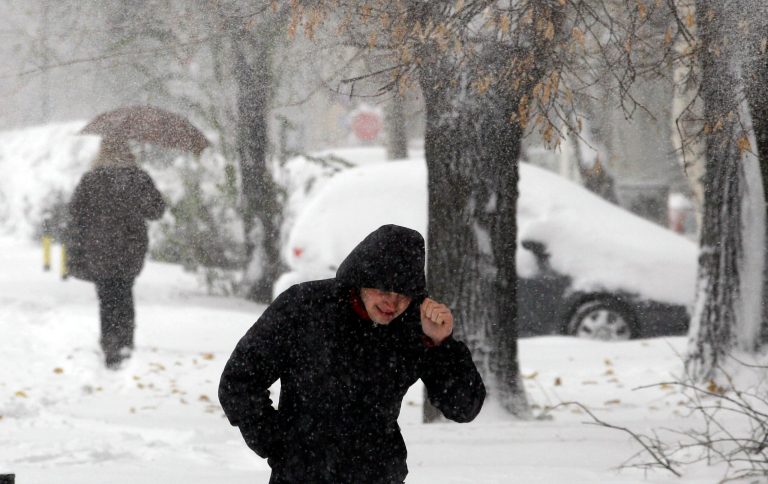  People walk through the snow covered street during the snow storm in Belgrade, Serbia, Sunday, Dec. 9, 2012. Freezing temperatures and heavy snowfall have killed at least 5 people and caused travel chaos across the Balkans. (AP Photo/Darko Vojinovic)  