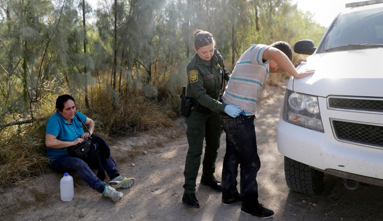 In this Aug. 11, 2017, photo, U.S. Customs and Border Patrol agents pick up immigrants suspected of crossing into the United States illegally along the Rio Grande near Granjeno, Texas. The Department of Homeland Security agency reported 310,531 apprehensions and 216,370 inadmissible people caught at various parts of the Mexico and Canada borders, as well as ports of entry from Oct. 1, 2016 through Sept. 30, 2017. 