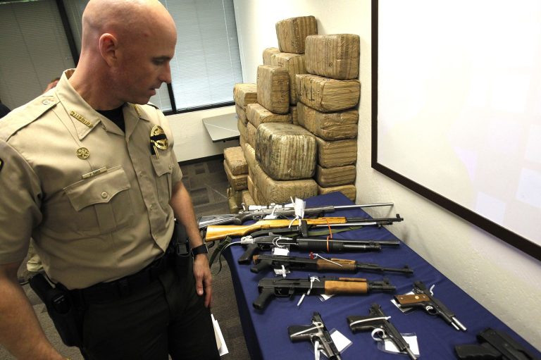 Pinal County Sheriff Paul Babeu examines some of the seized evidence at the border. (AP Photo/Ross D. Franklin)