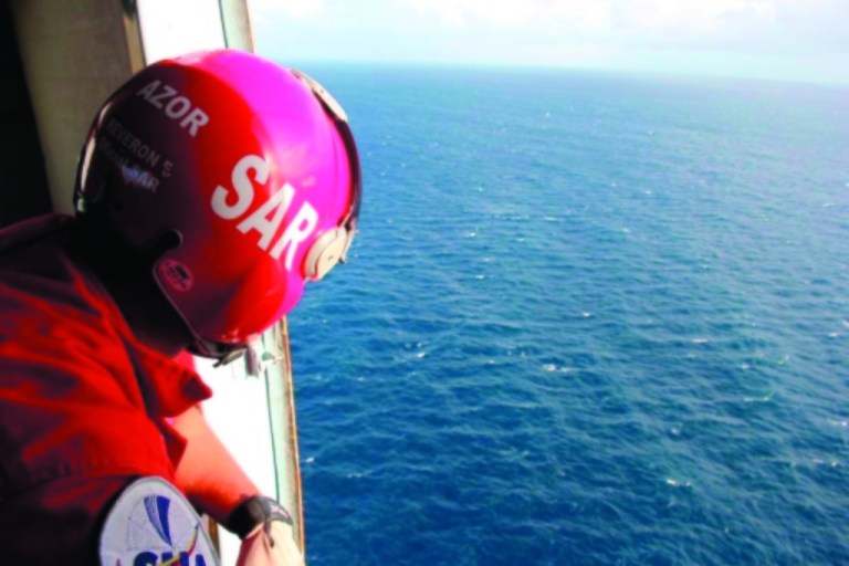 In this photo provided by Venezuela's Ministry of the Interior and Justice Press Office, a member of Venezuela's National Civil Aviation Institute looks out at the ocean during the search for a plane that went missing near Los Roques, Venezuela, Sunday, Jan. 6, 2013. The search for a missing plane carrying Italian fashion executive Vittorio Missoni and five other people has entered its third straight day on Sunday with no signs of the aircraft. The small, twin-engine plane was reported missing hours after taking off Friday from Los Roques, a string of islands and islets popular among tourists for their white beaches and coral reefs. (AP Photo/Venezuela Ministry Interior and Justice Office Press)
