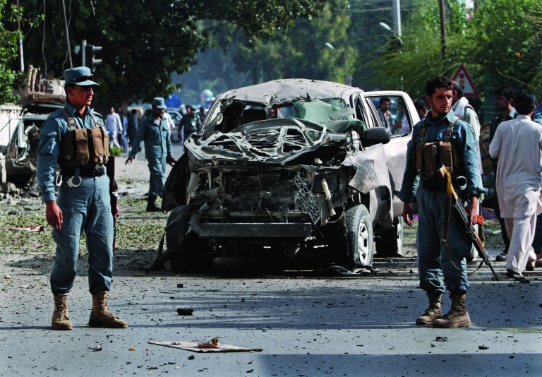 Afghan Police officers inspect the wreckage of vehicle after a bomb explosion in the city of Jalalabad east of Kabul, Afghanistan, Monday, Aug. 13, 2012. At least five civilians were injured as a bomb targeting a government employees' bus went off Monday morning, a police source said. (AP Photo/Rahmat Gul)