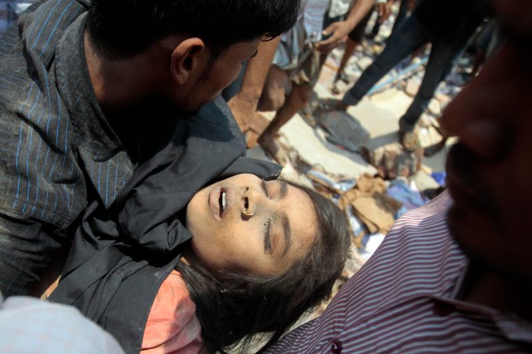 Rescue workers pull a woman out from the rubble after an eight-story building housing several garment factories collapsed in Savar, near Dhaka, Bangladesh, Wednesday, April 24, 2013. Dozens were killed and many more are feared trapped in the rubble. (AP Photo/ A.M. Ahad)
