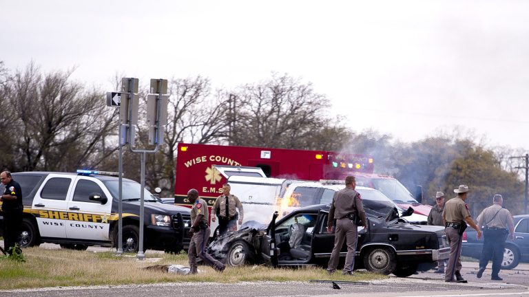 Emergency personnel are on the scene of a crash and shootout with police involving the driver of a black Cadillac with Colorado plates in Decatur, Texas, Thursday, March 21, 2013. The driver led police on a gunfire-filled chase through rural Montague County, crashed his car into a truck in Decatur, opened fire on authorities and was shot, officials said. Texas authorities are checking whether the Cadillac is the same car spotted near the home of Colorado prisons chief Tom Clements, who was shot and killed when he answered the door Tuesday night. (AP Photo/Wise County Messenger, Jimmy Alford) MANDATORY CREDIT, MAGS OUT