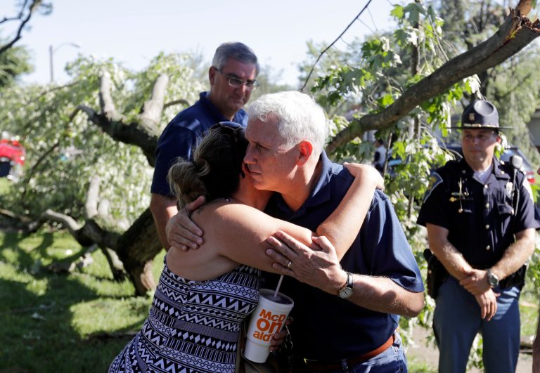 Republican vice presidential candidate, Indiana Gov. Mike Pence hugs Heidi Otiker after speaking with her, Thursday, Aug. 25, 2016, in Kokomo, Ind. Otiker's home was damaged by a tornados that passed through the area Wednesday afternoon. (AP Photo/Darron Cummings)