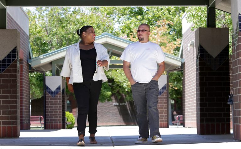 Elk Grove Unified School District teacher Michael Jones and his former student Kandance Stagner, a foster child, walk around Laguna Creek High School. (AP Photo/Rich Pedroncelli)

