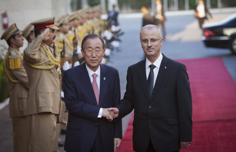 United Nations Secretary-General Ban Ki-moon, left, shakes hands with Palestinian Prime Minister Rami Hamdallah upon his arrival in the West Bank city of Ramallah, Tuesday, July 22, 2014. The two men were set to hold a joint news conference regarding the Israel-Hamas conflict. (AP Photo/Majdi Mohammed)