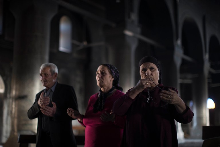 Iraqi Christians pray at the Church of the Immaculate Conception, damaged by Islamic State fighters during their occupation of Qaraqosh, east of Mosul, Iraq, Saturday, Nov. 12, 2016. Qaraqosh, the biggest Christian town on the Nineveh plains in Iraq's north, fell to the Islamic State group in 2014 and was recently retaken by Iraqi government forces. (AP Photo/Felipe Dana)