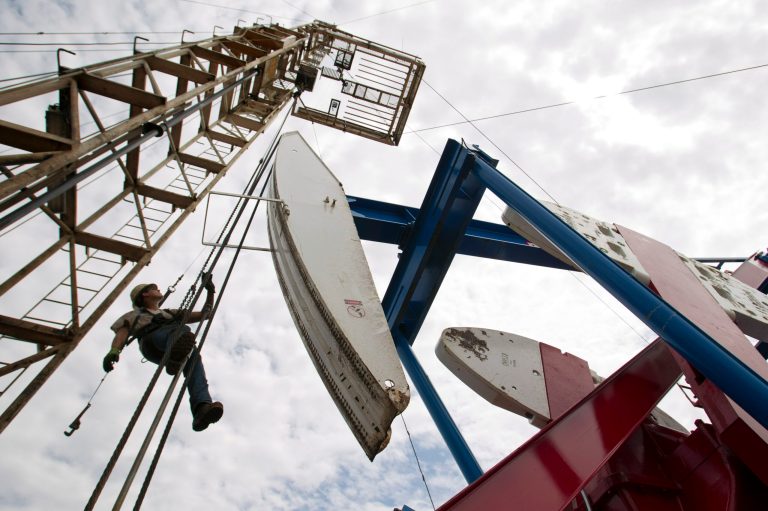 FILE - In this Tuesday, July 26, 2011 file photo, Ben Shaw hangs from an oil derrick outside of Williston, N.D. (AP File)