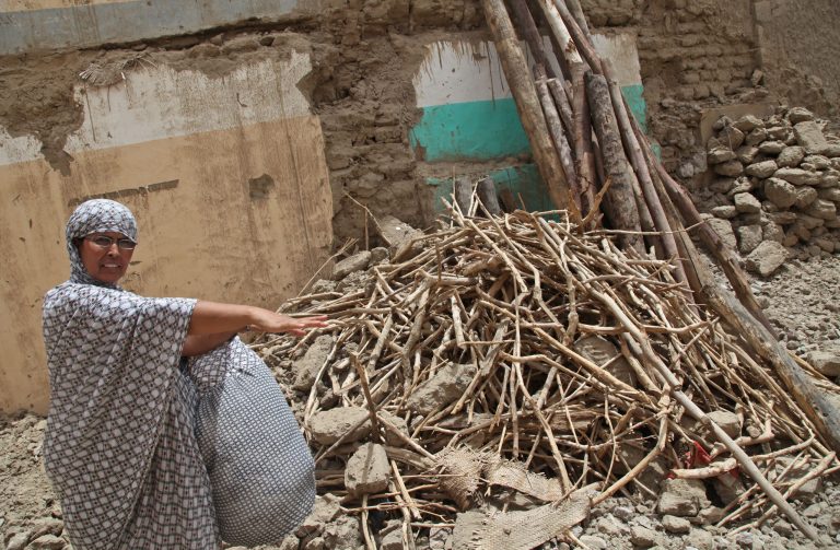 In this photo taken Tuesday, Aug. 26, 2014,  Fadimata Walet Abdou Salam shows the inside of her home were she lived before becoming a refugee in Timbuktu, Mali. A pile of stones and wood was all that remained of the house where Fadimata Walet Abdou Salam once lived when she and her young daughters returned after more than a year of sleeping in a tent as refugees in a foreign country. Looters had stolen the windows and doors, and then heavy rains transformed the earthen walls into a heap of mud after she had to abandon her home in Timbuktu following unrest and violence. (AP Photo/Baba Ahmed)