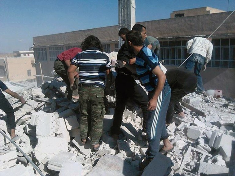 This photo provided by an anti-Bashar Assad activist group Edlib News Network (ENN), which has been authenticated based on its contents and other AP reporting, shows Syrians inspecting the rubble of houses that were destroyed by airstrikes from the Syrian government forces, in Idlib province, northern Syria, Sunday, June 15, 2014. Government forces flushed opposition fighters from their last redoubts in northwestern Syria near the Turkish frontier on Sunday, capturing two villages and restoring government control over the border crossing, activists and state media said. (AP Photo/Edlib News Network ENN)