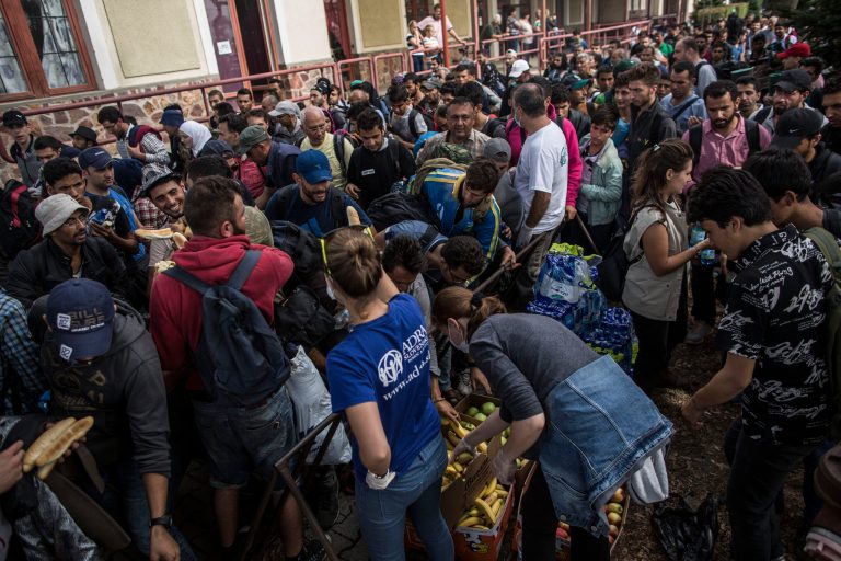 Syrian refugees take food from volunteers in Hegyeshalom, Hungary, near the border with Austria on Tuesday Sept. 15, 2015. (AP Photo/Manu Brabo)