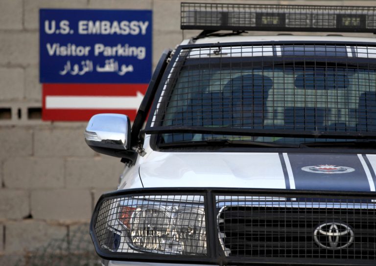   FILE - In this Aug. 6, 2013, photo, a Bahraini police officer sits in a police car at a new checkpoint near the U.S. Embassy in Manama, Bahrain. Eighteen of the 19 U.S. embassies and consulates that were closed in the Middle East and Africa because of a terrorist threat will reopen on Sunday or Monday, the State Department said Friday, Aug. 9, 2013. (AP Photo/Hasan Jamali)  