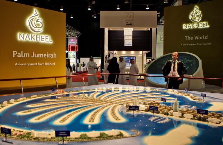 FILE - In this file photo taken Monday Oct. 5, 2009, a visitor looks at the Palm Jumeirah model at the Nakheel stand at the Cityscape exhibition in Dubai, United Arab Emirates. Dubai's developer Nakheel behind the famed man-made palm-shaped islands said Wednesday, Aug. 20, 2014, that it is repaying 7.9 billion dirhams, or roughly $2.15 billion this month - nearly four years before the last installment is due. (AP Photo/Kamran Jebreili, File)
