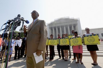 Field Director Charles White of the National Association for the Advancement of Colored People (NAACP) speaks at a podium outside the U.S. Supreme Court building on June 25, 2013 in Washington, DC. The court ruled that Section 4 of the Voting Rights Act, which aimed at protecting minority voters, is unconstitutional. (Photo by Win McNamee/Getty Images)