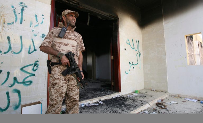 A Libyan military guard stands in front of one of the U.S. Consulate's burnt out buildings in Benghazi, Libya, Friday, Sept. 14, 2012. (AP Photo/Mohammad Hannon)
