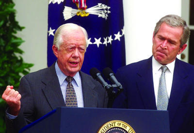 Former President Jimmy Carter, left, speaks in the Rose Garden in 2001 with then-President George W. Bush. (AP Photo/Ron Edmonds)