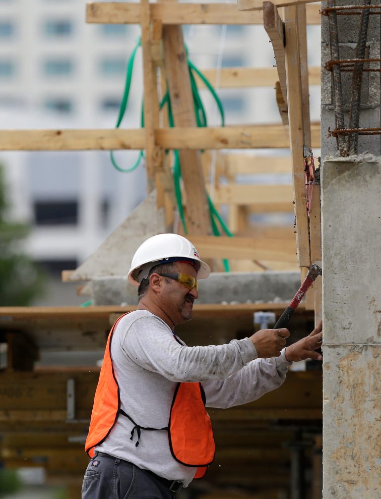 In this Friday, May 16, 2014 photo, a builder works on the site of the SoMa at Brickell apartment building in downtown Miami. The National Association of Home Builders releases housing market index for July on Wednesday, July 16, 2014. (AP Photo/Lynne Sladky)